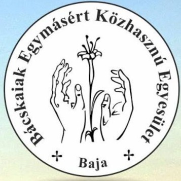 A képen egy kör logó látható, benne Bácskaiak Egymásért Közhasznú Egyesület, Baja felirat, középen kettő kéz, közte egy szál virág.