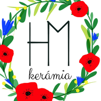 A képen egy H és egy M betű, alatta kerámia felirat, körben virágok.