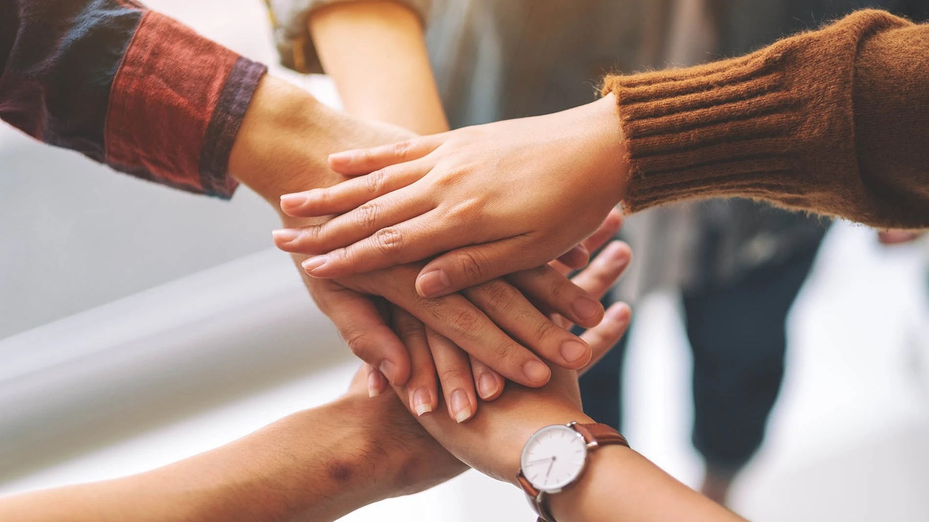 Kezek tennyérrel lefelé egymásra helyezve az összefogás jelképeként. 