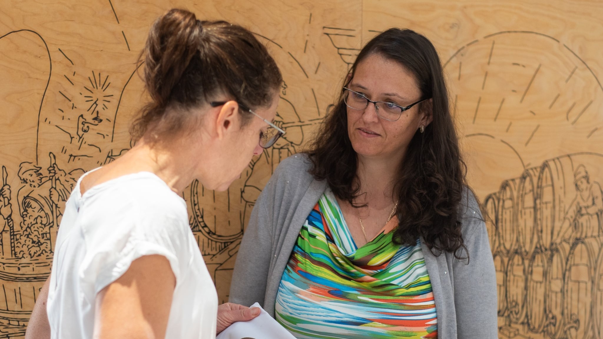 A képen két nő beszélget.