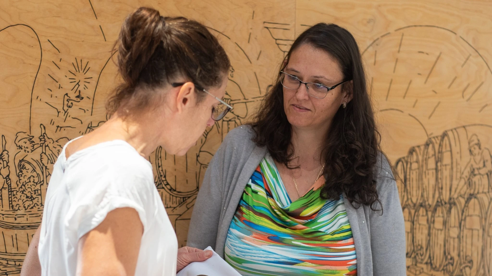 A képen két nő beszélget.