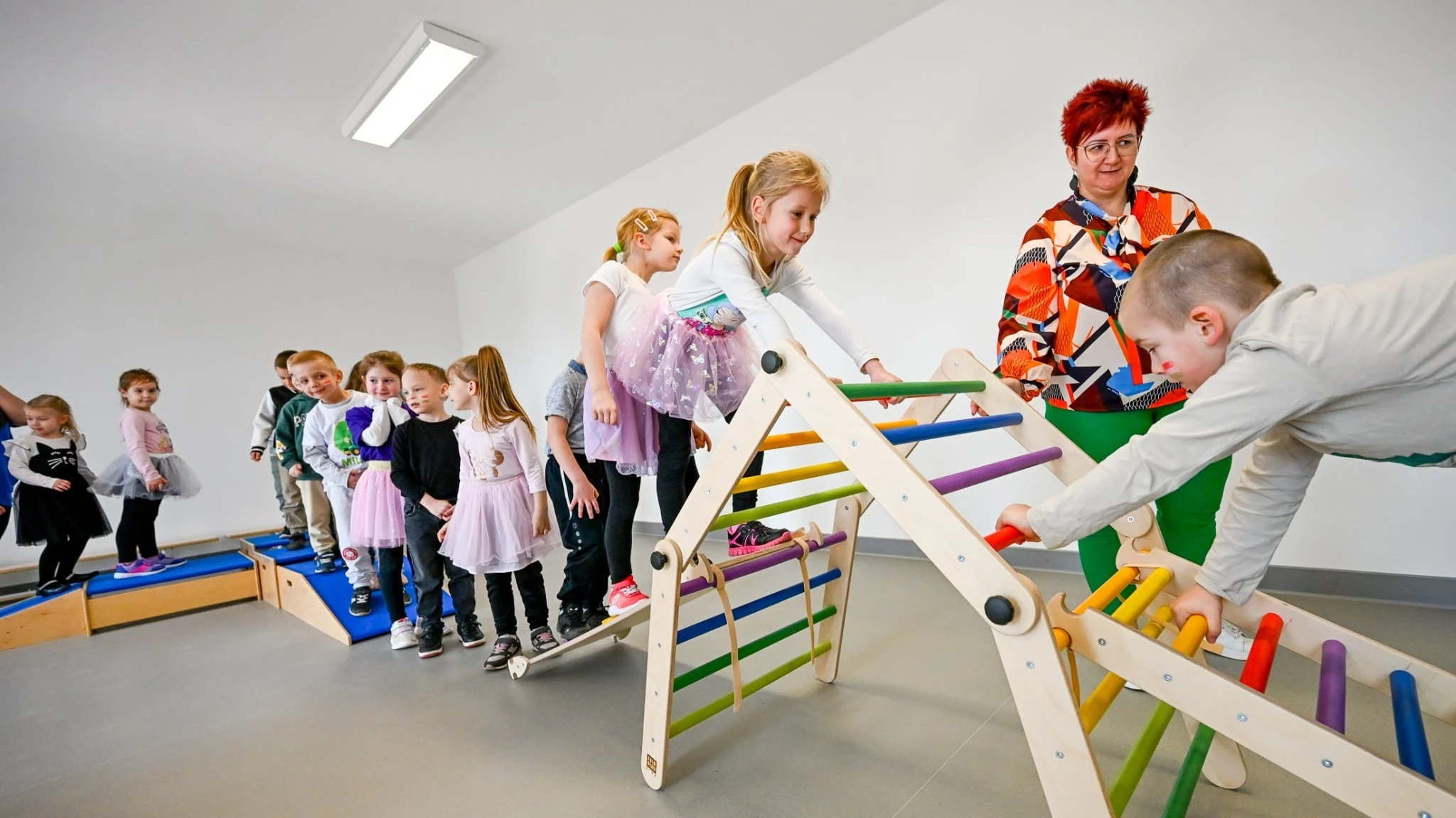 A képen gyermekek játszanak egy tornaszobában.