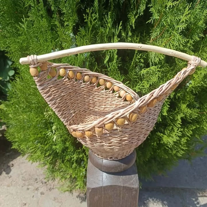 A képen egy papírfonással készült különleges formájú kosár látható.