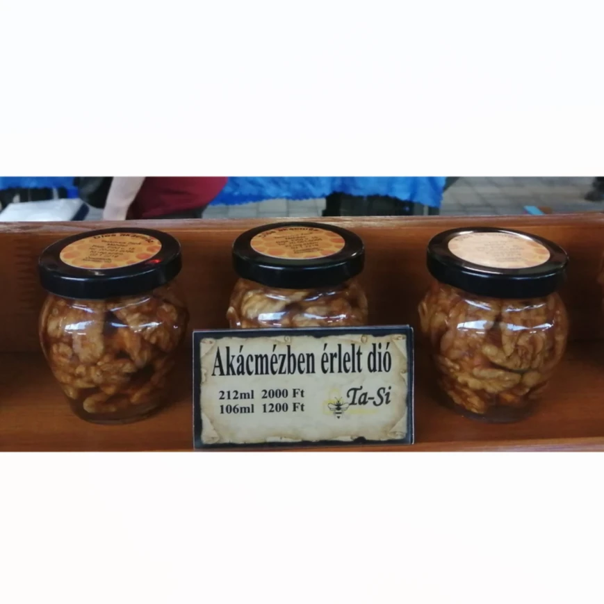 A képen 3 üveg akárcmézben érlelt dió látható.