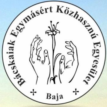 A képen egy kör logó látható, benne Bácskaiak Egymásért Közhasznú Egyesület, Baja felirat, középen kettő kéz, közte egy szál virág.